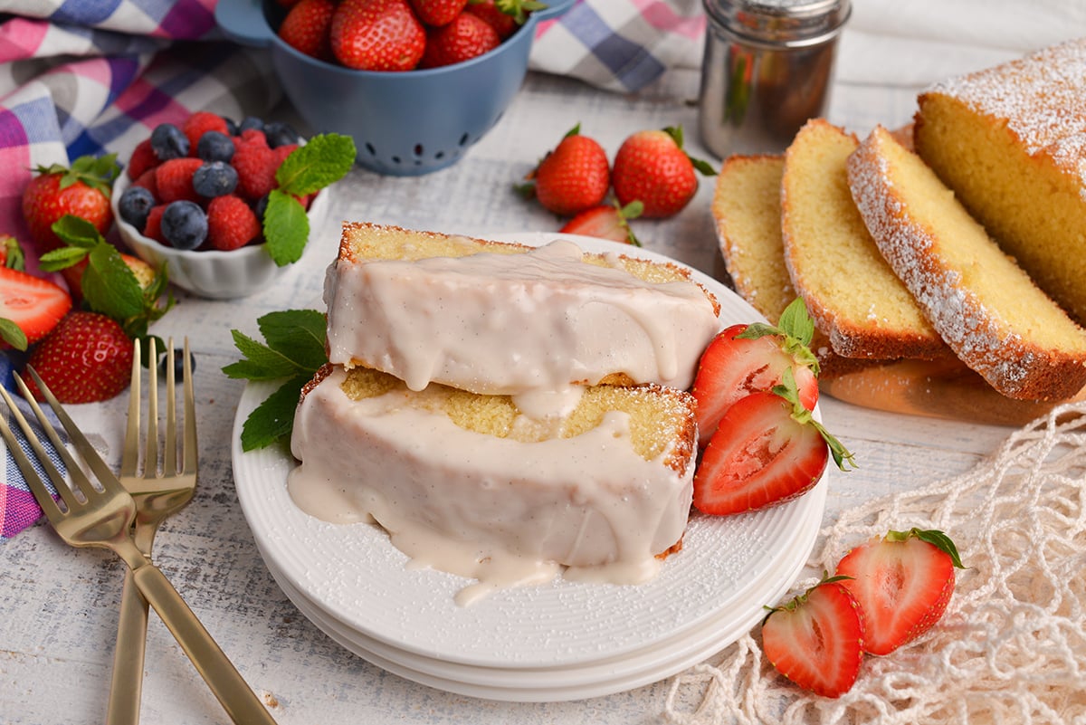 two slices of vanilla pound cake topped with glaze on plate