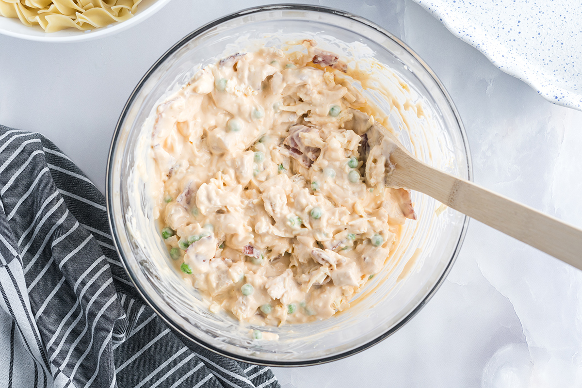 glass mixing bowl with chicken noodle casserole ingredients