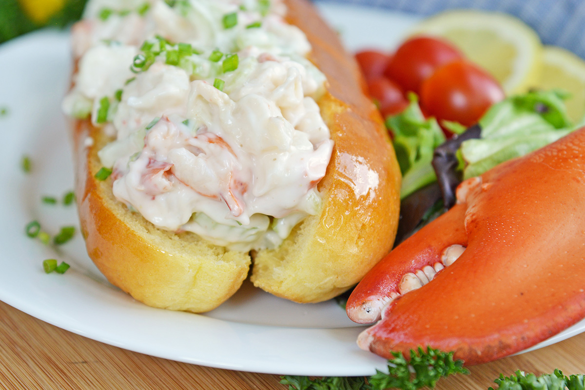 side view of cold lobster roll on split top bread