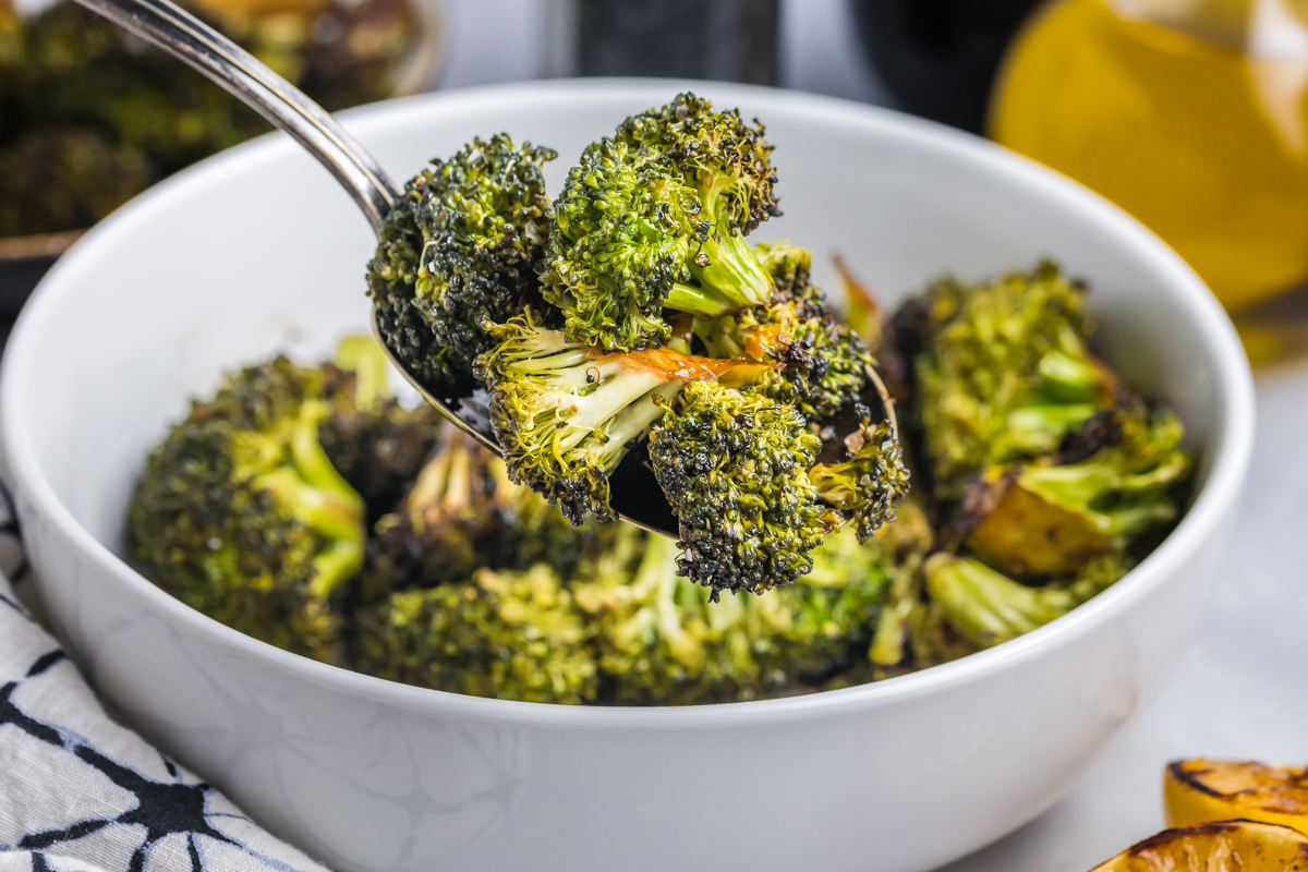 angled shot of spoon full of grilled broccoli