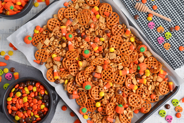 overhead of snack mix on a rimmed baking sheet with parchment paper
