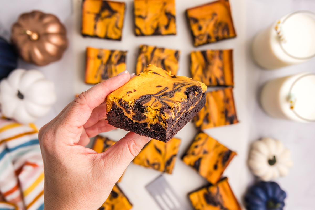overhead shot of hand holding pumpkin brownie