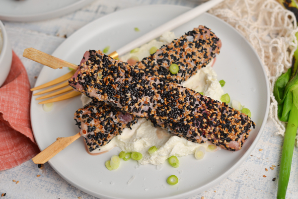 overhead shot of two sticks of sesame crusted tuna on a plate