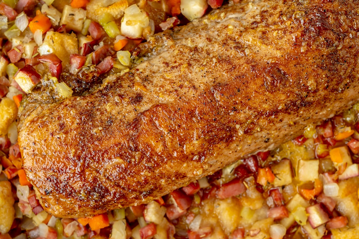 close up overhead shot of baking dish of apple spiced pork tenderloin and stuffing