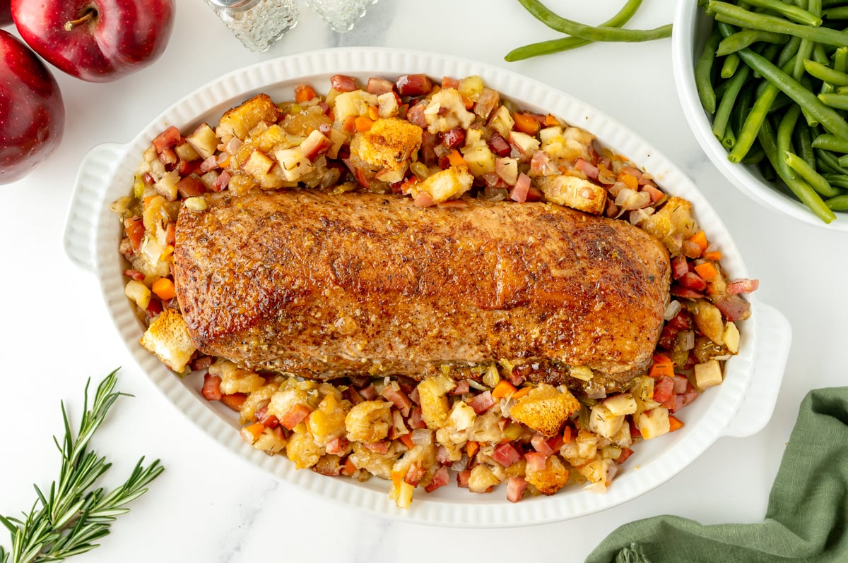 overhead shot of baking dish of apple spiced pork tenderloin and stuffing