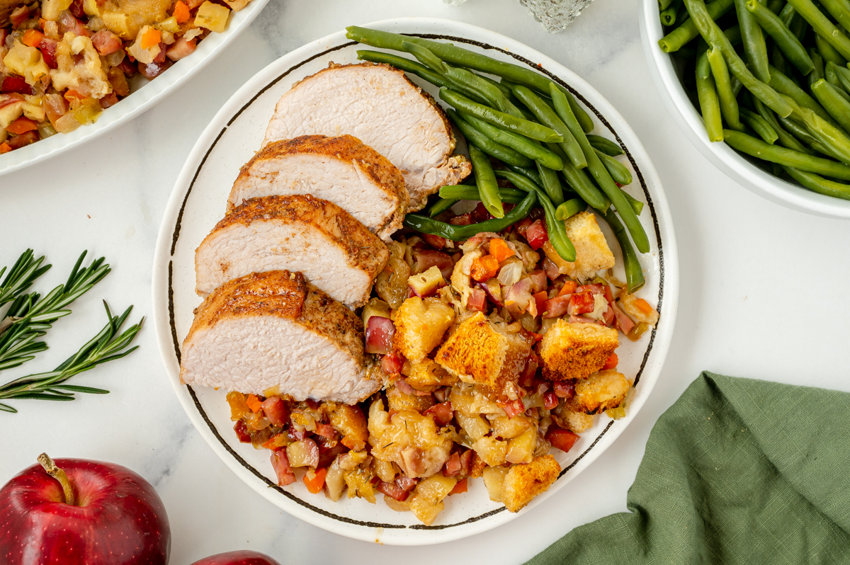 overhead shot of plate of stuffing, green beans and pork tenderloin
