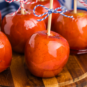 close up angled shot of candied apples on wooden board