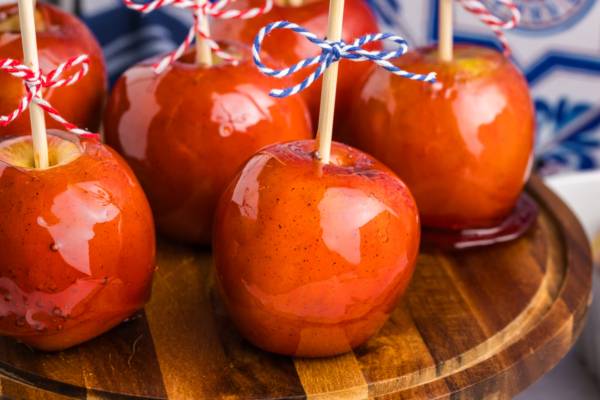 close up angled shot of candied apples on wooden board