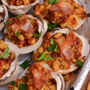 close up angled shot of clams casino topped with bacon