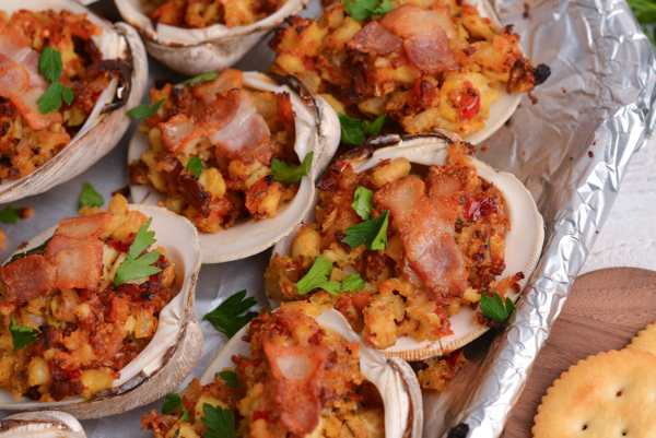 close up angled shot of clams casino topped with bacon