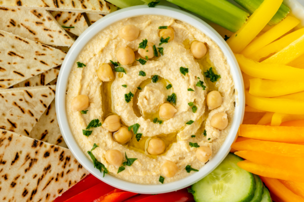 close up overhead shot of bowl of hummus with veggies