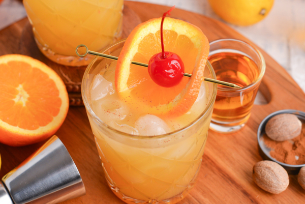 close up angled shot of maple whiskey sour on wooden board