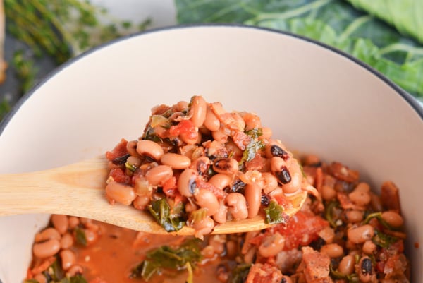 angled shot of black eyed peas on wooden spoon