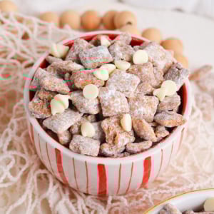 angled shot of white and red bowl full of cinnamon puppy chow