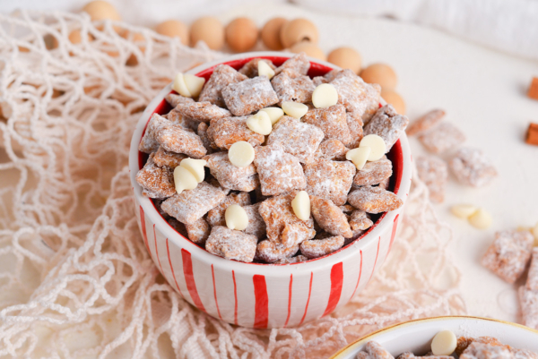 angled shot of white and red bowl full of cinnamon puppy chow