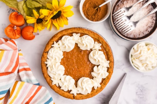 overhead shot of whipped cream on sweet potato pie