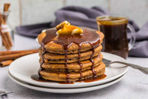straight on shot of butter and syrup over stack of gingerbread pancakes