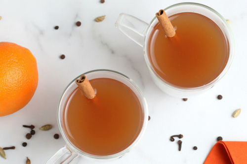 overhead shot of two mugs of mulled cider