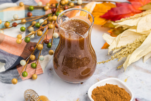 angled shot of pitcher of pumpkin spice syrup