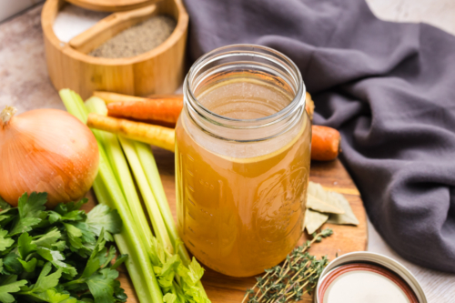 angled shot of mason jar of turkey stock