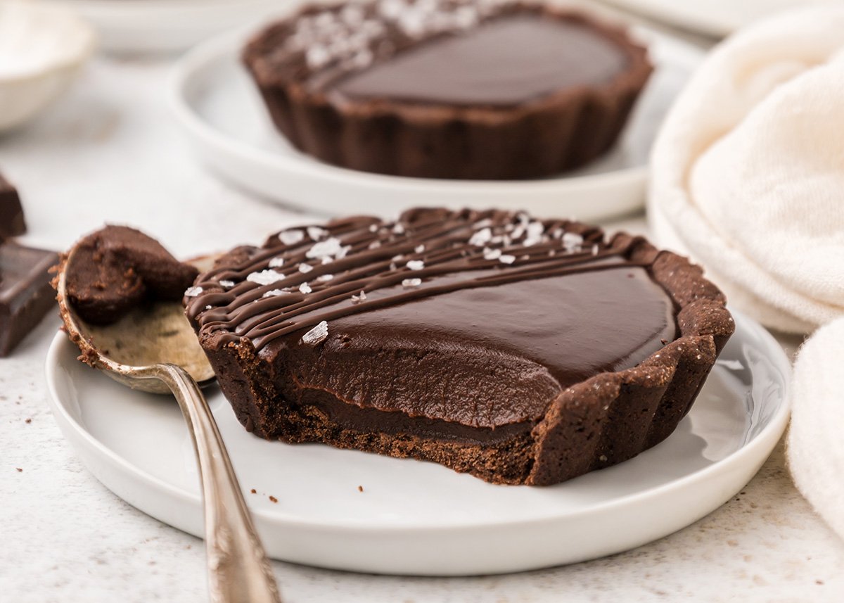 close up of bite taken out of chocolate tartlet
