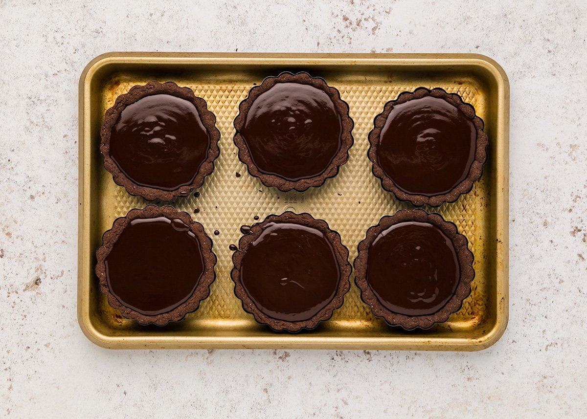 overhead shot of chocolate poured into chocolate crusts