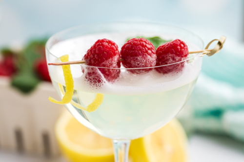 close up shot of raspberries in cocktail