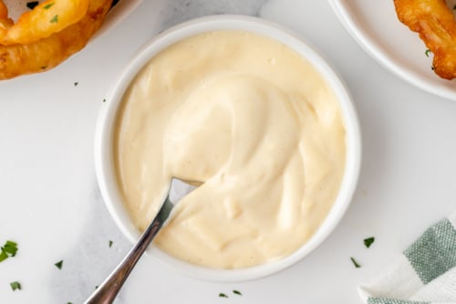 overhead shot of spoon in bowl of mustard aioli