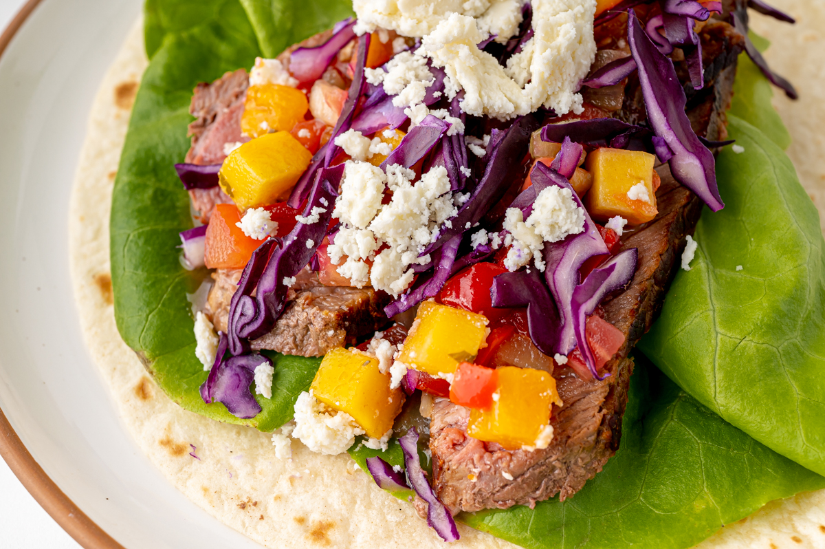 close up angled shot of tropical beef taco on plate
