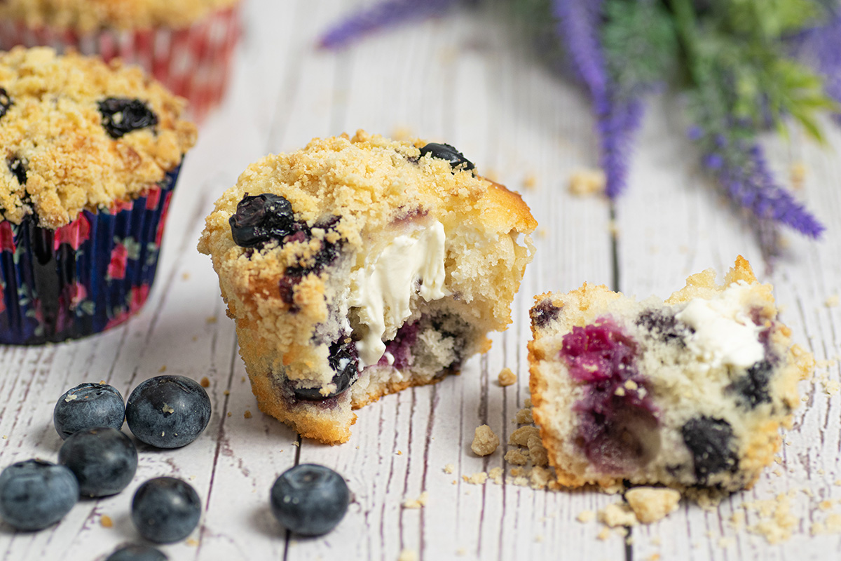 angled shot of blueberry cream cheese muffin cut in half