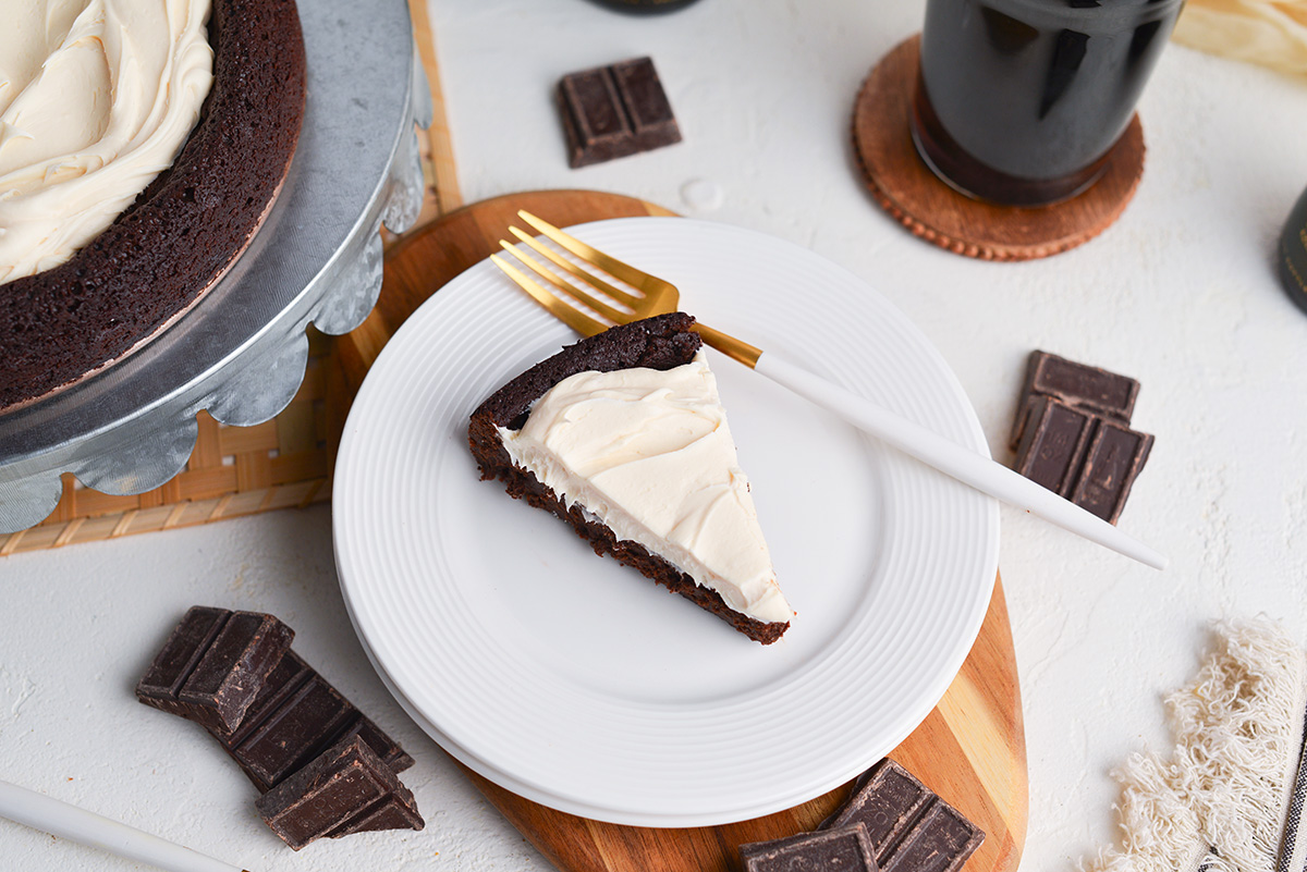 angled shot of slice of flourless stout cake on plate with fork