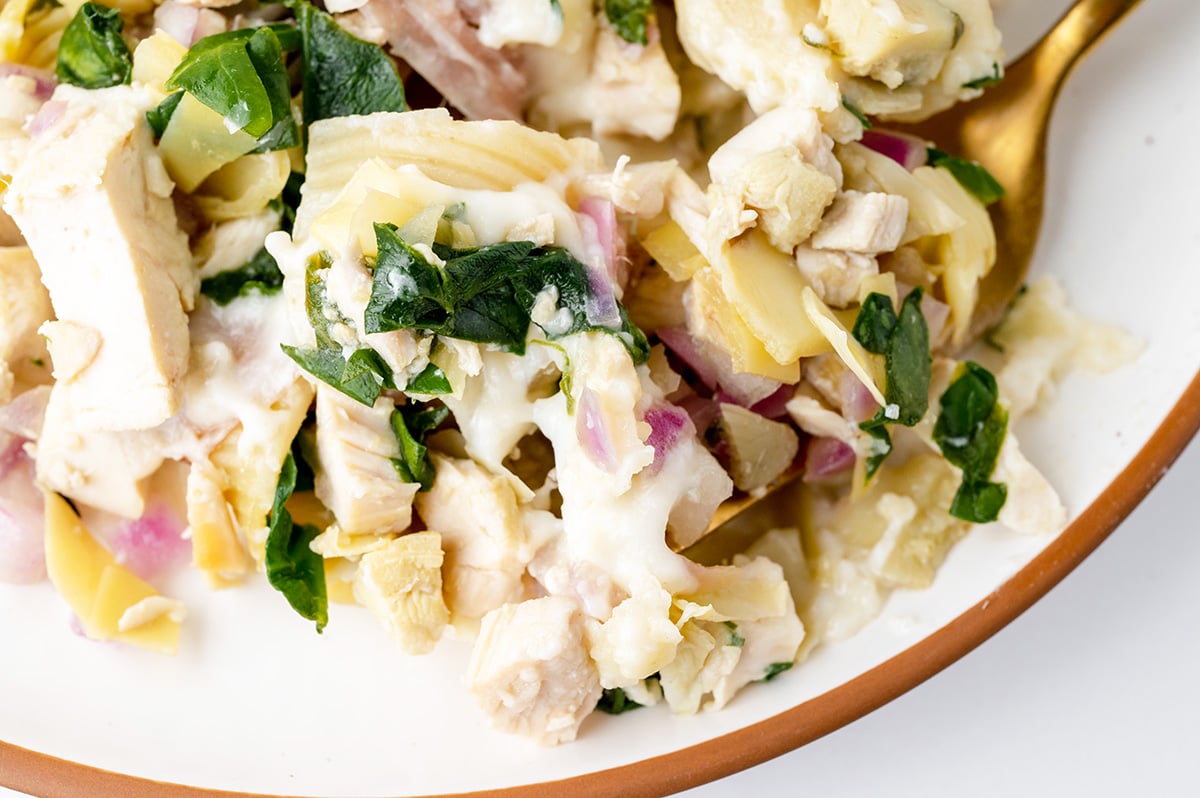 fork digging into chicken stuffed shells on plate