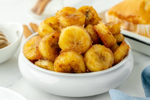 angled shot of bowl of fried bananas