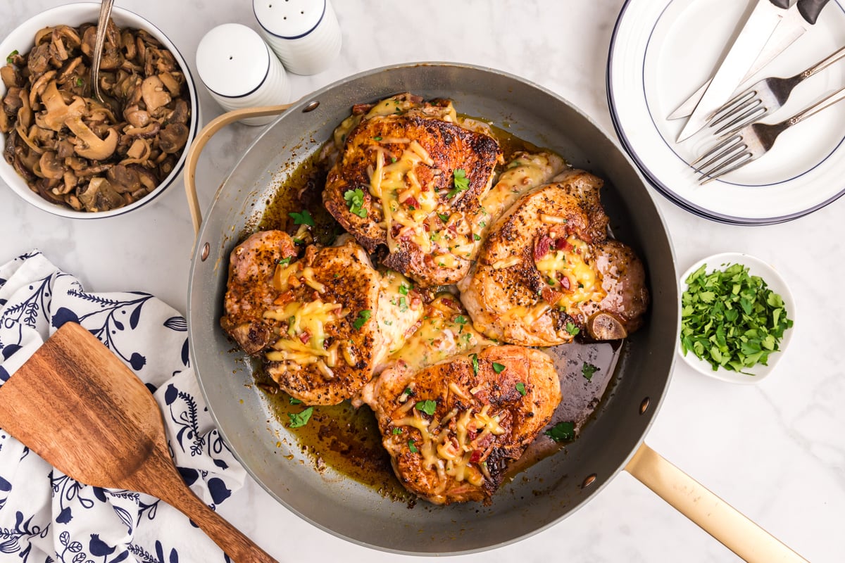 overhead shot of baked stuffed pork chops in skillet