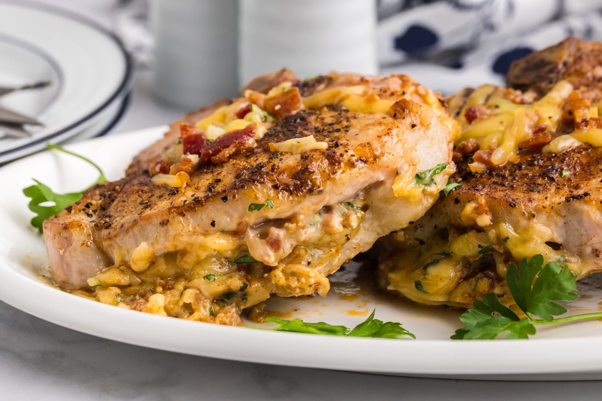 close up angled shot of baked stuffed pork chops on platter