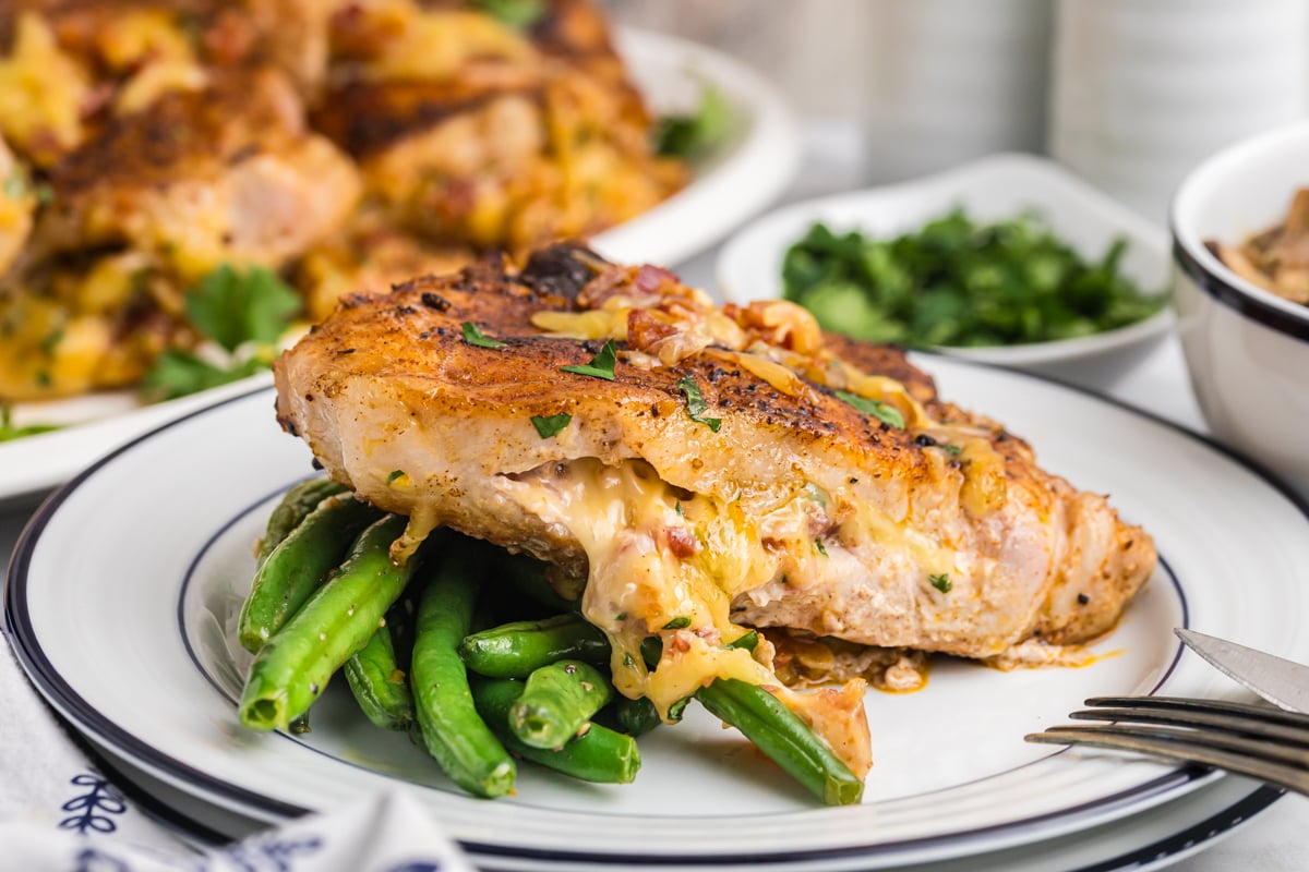baked stuffed pork chop over green beans on plate