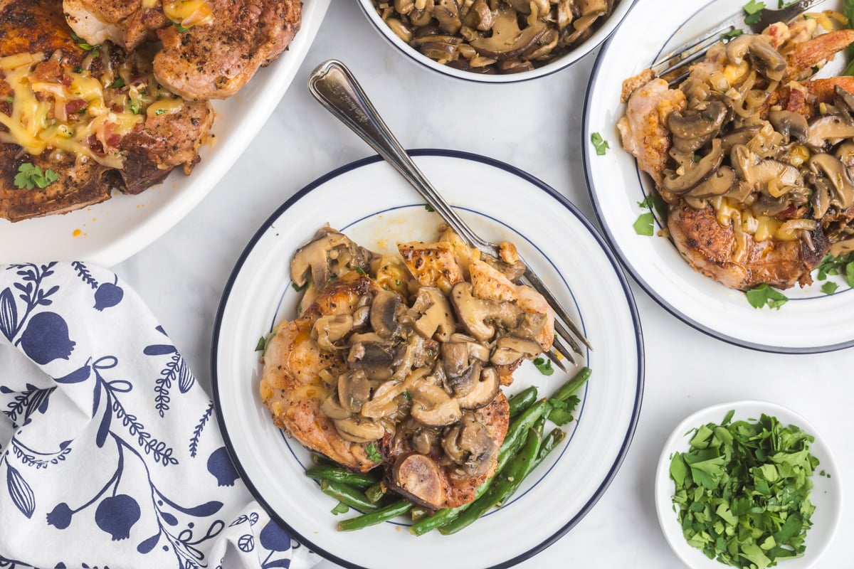 overhead shot of pork chop on plate topped with mushrooms