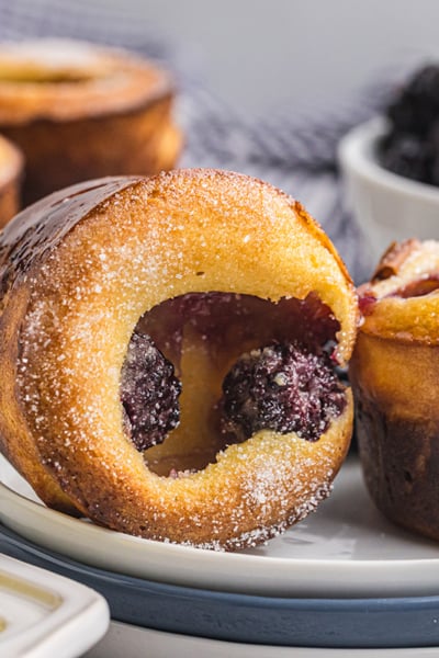 close up straight on shot of two blackberry popovers on a plate