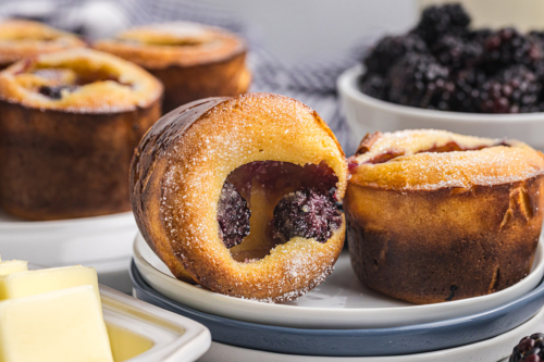 close up straight on shot of two blackberry popovers on a plate