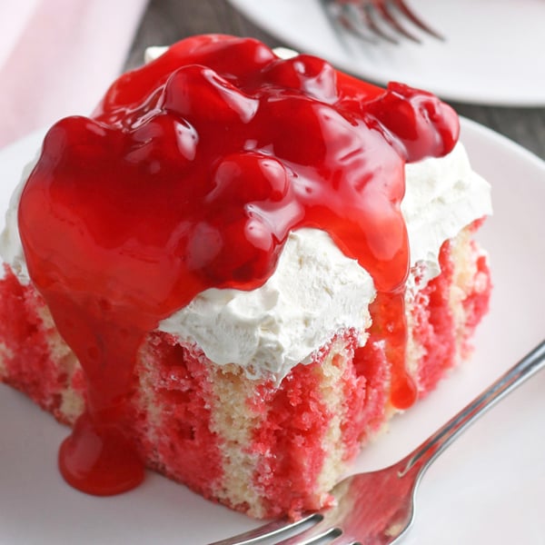 A piece of cake on a plate, with Cherry