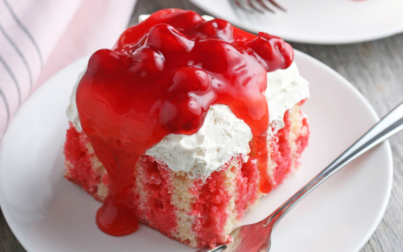 A piece of cake on a plate, with Cherry