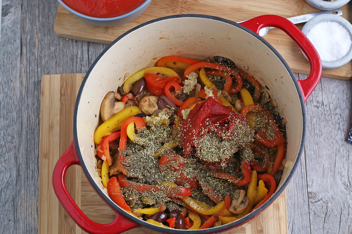 overhead shot of seasoning added to veggies in dutch oven