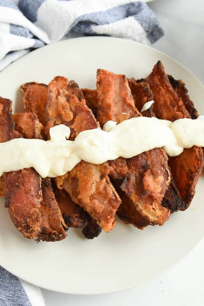 chicken fried bacon on a white platter