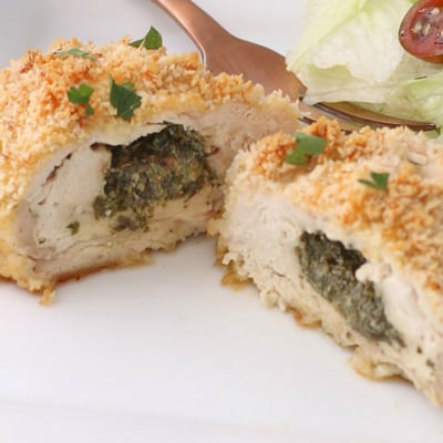 close up of chicken kiev cut in half on plate