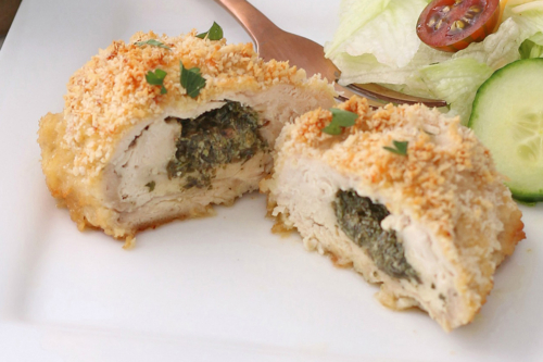 close up of chicken kiev cut in half on plate