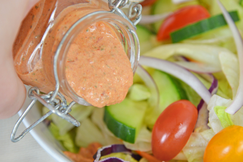 dressing pouring onto salad