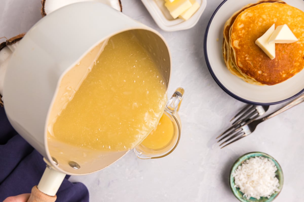 coconut syrup pouring out of pan into jar