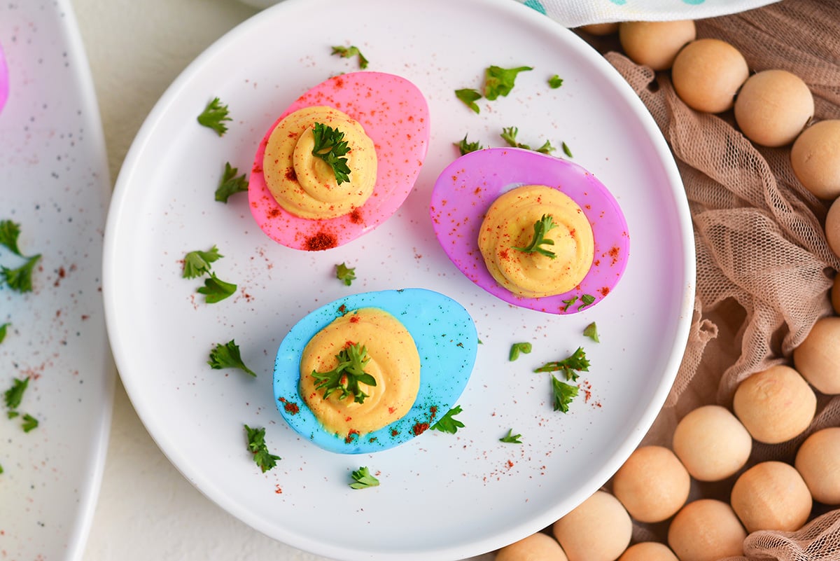 close up overhead shot of plate of three dyed deviled eggs
