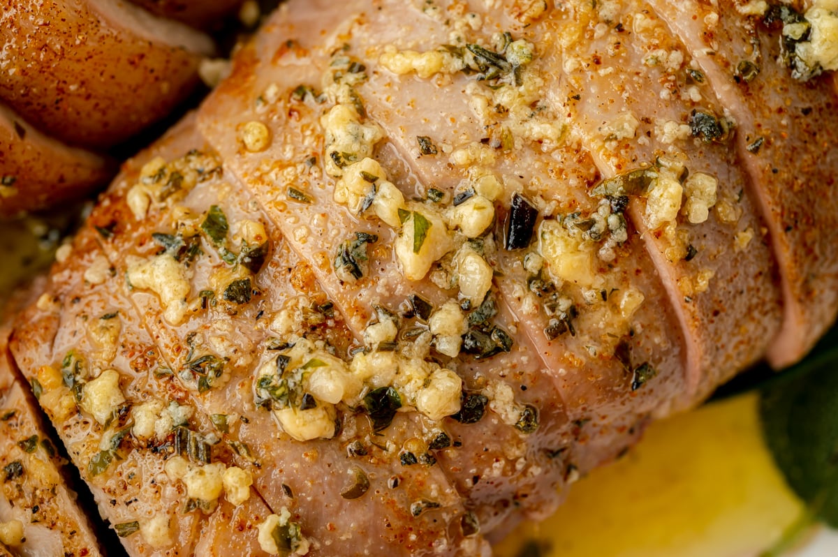 close up of garlic butter on pork tenderloin