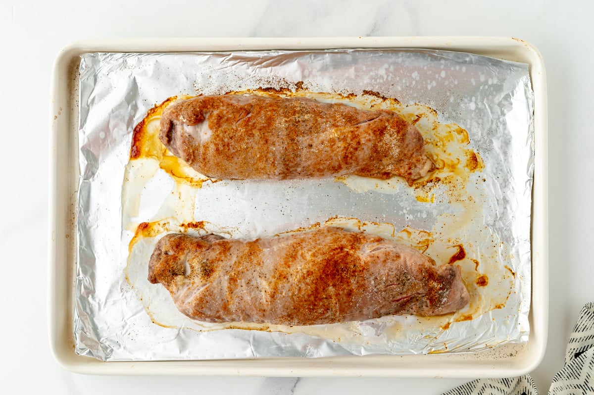 overhead shot of two baked pork tenderloins on sheet pan